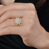 Close-up of a hand wearing a diamond ring with a black background