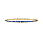 Gold bracelet with sapphires on a white background