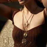 Woman wearing layered necklaces and bracelets outdoors
