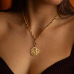 Gold necklace with a horse pendant on a person's neck.