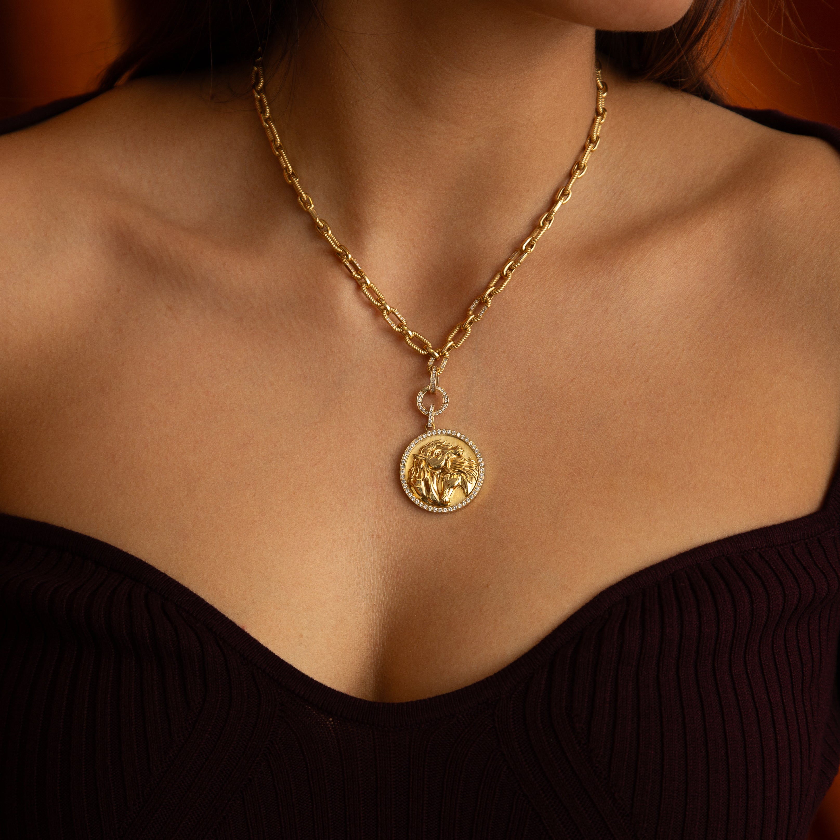 Gold necklace with a pendant on a person's neck.