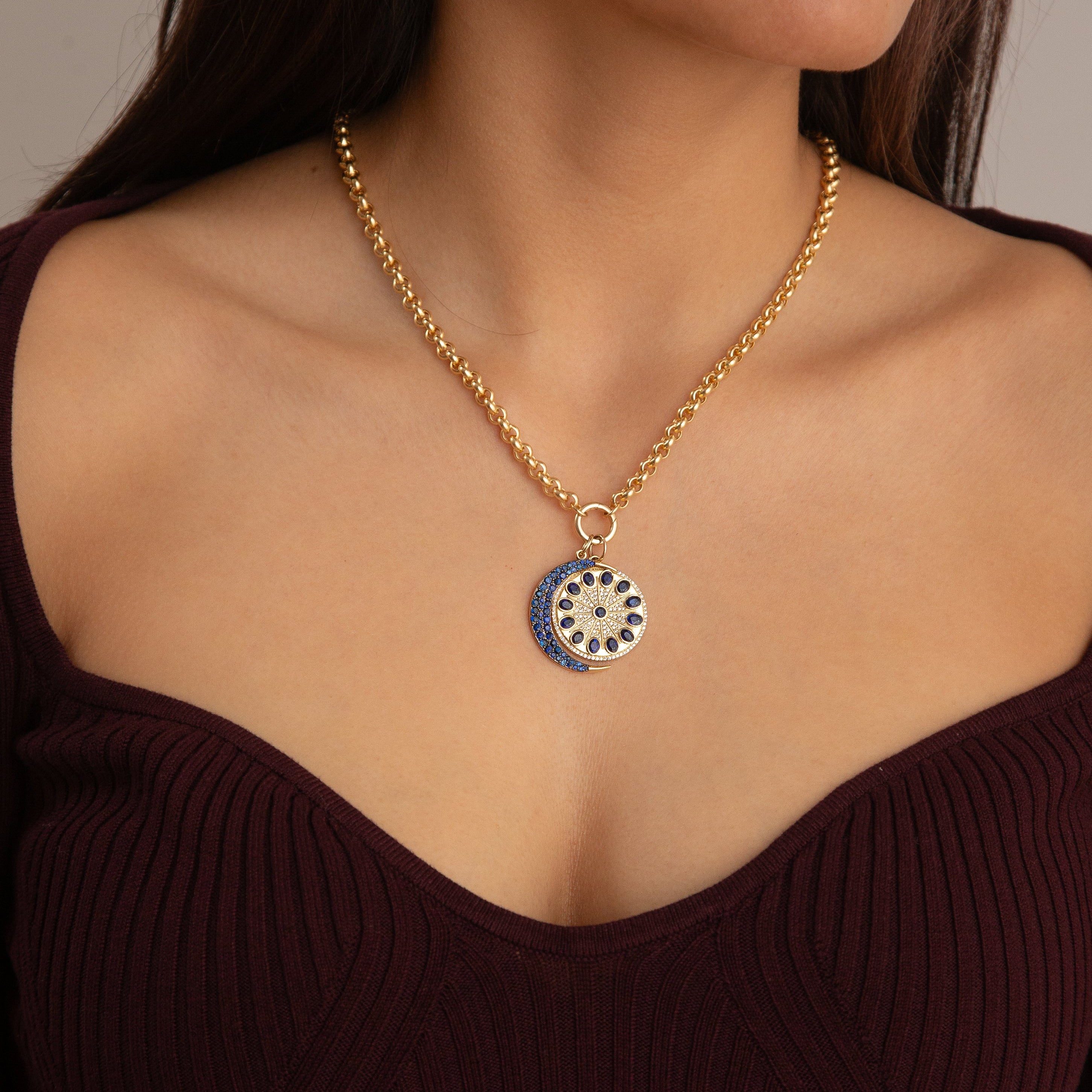 Model wearing sapphire crescent moon charm on gold rolo chain