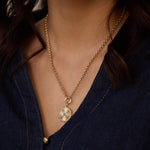 Our radiant sun medallion shines with diamond rays and a vibrant emerald center, strung on a classic gold rolo chain.