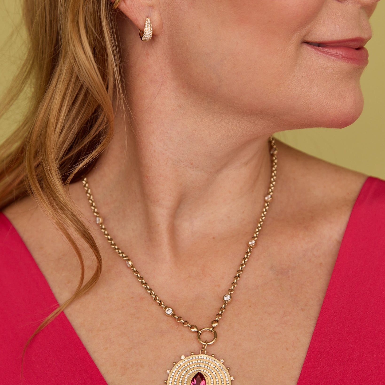 Close-up of a woman wearing the Lionheart Aurelia tourmaline charm in 14K gold with diamond bead border 
